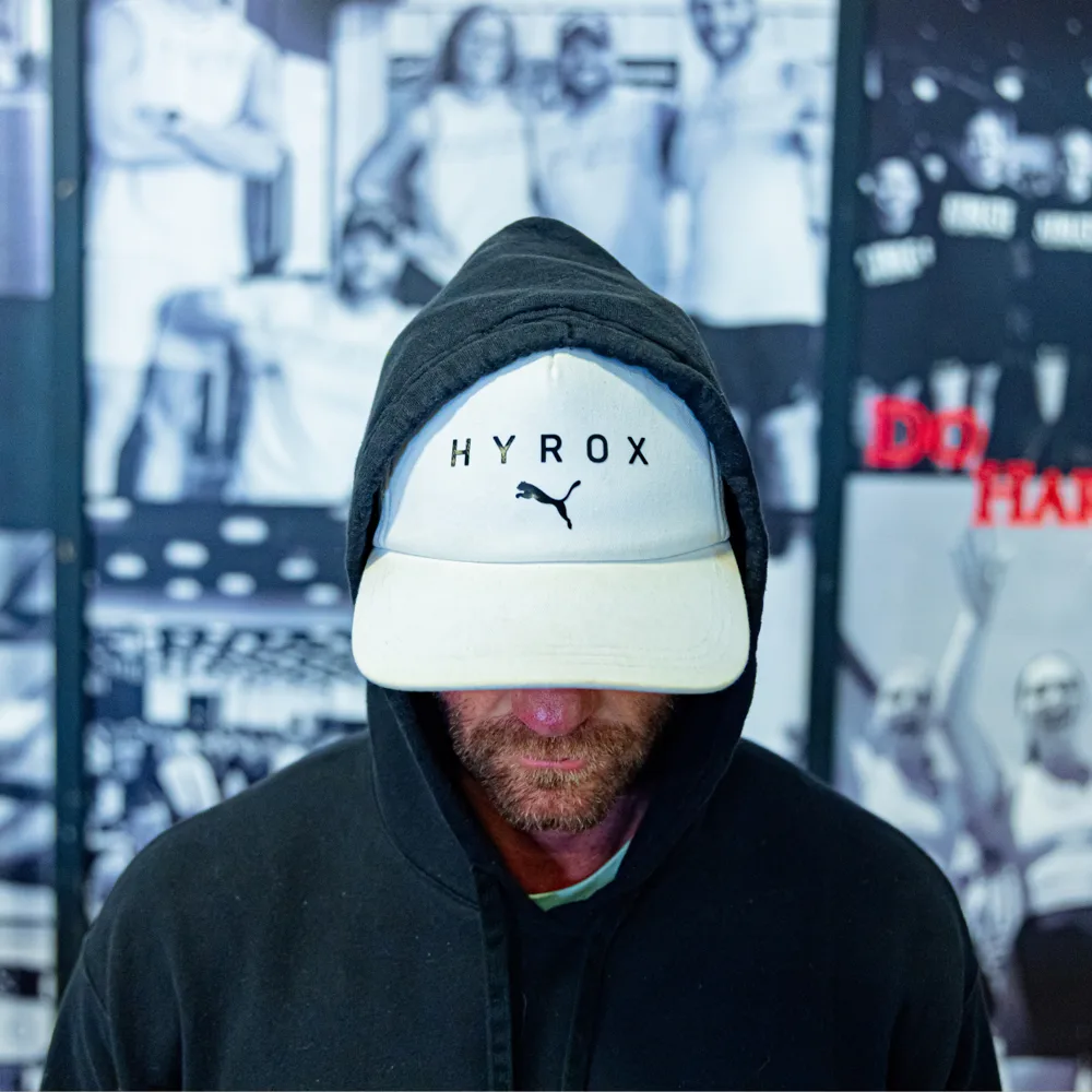 Hyrox athlete in a Puma Hyrox cap at True Grit Fitness, an official Hyrox affiliate gym near Edmond, Oklahoma