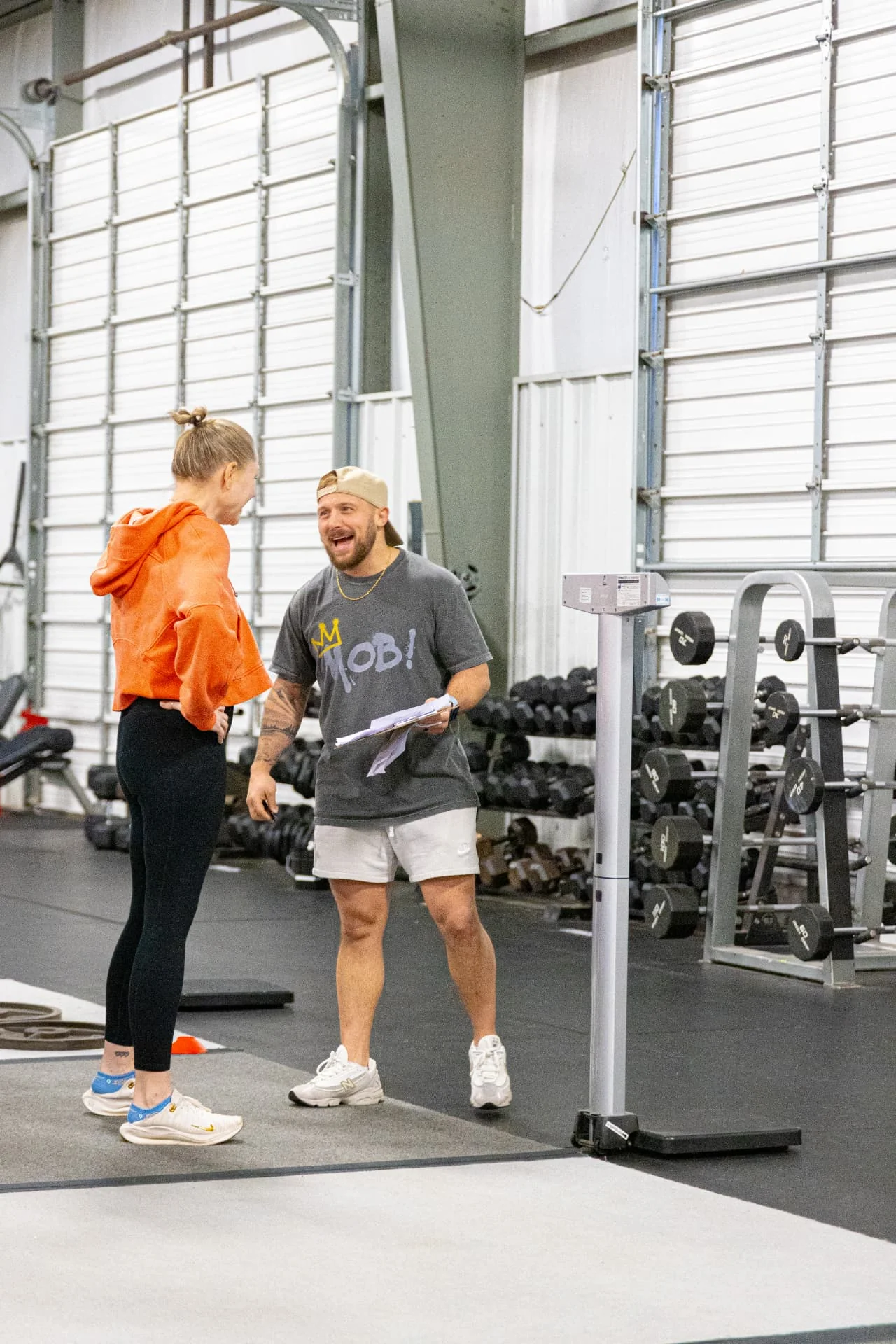 Personal trainer coaching a member through a dumbbell hip bridge at True Grit Fitness