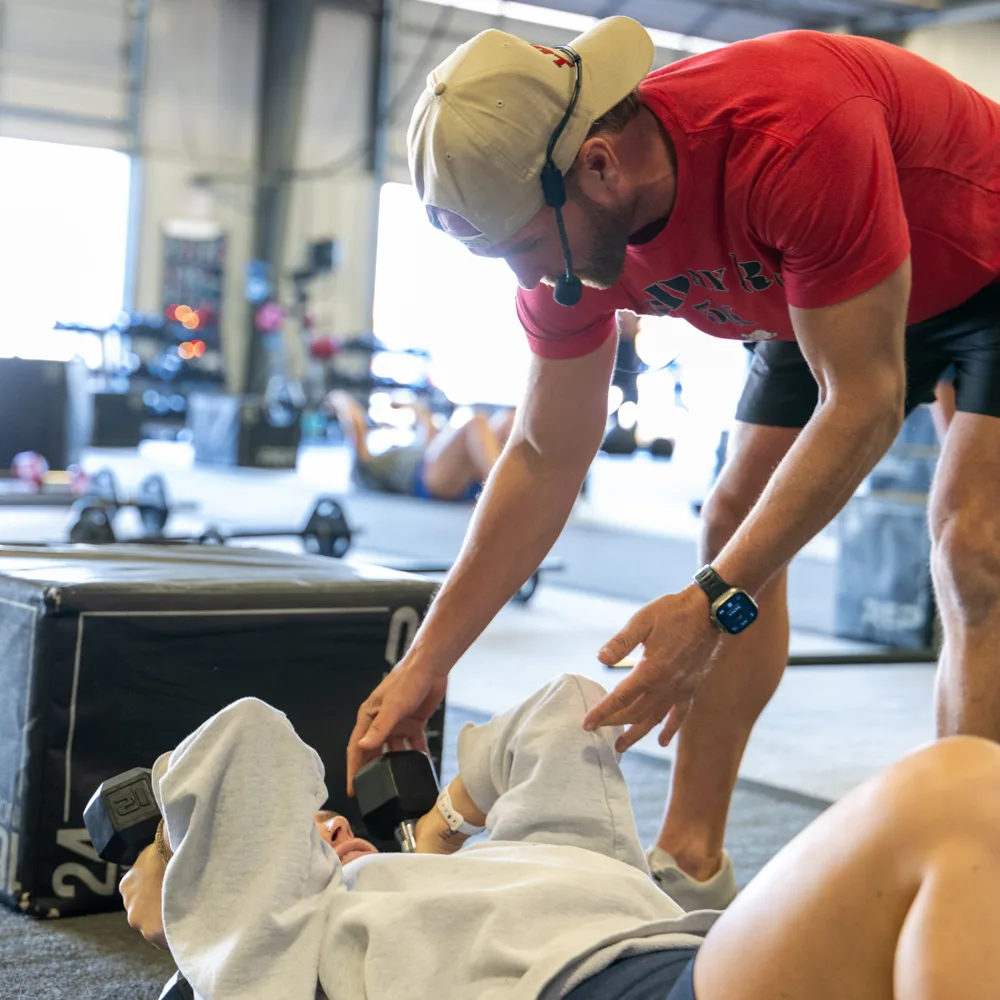 True Grit Fitness personal trainer coaching a client through a dumbbell press in Edmond, Oklahoma