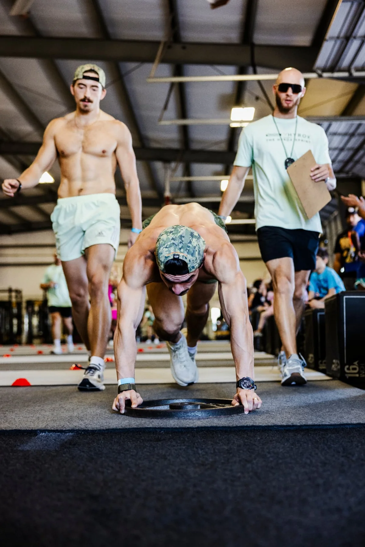Devan Barger judging an athlete during the HYROX Sprint burpee broad jump at True Grit Fitness in Edmond, Oklahoma