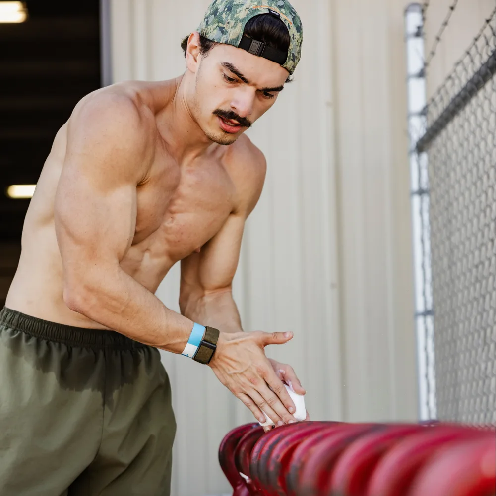 Hybrid athlete chalking up before sled push training at True Grit Fitness in Edmond, Oklahoma