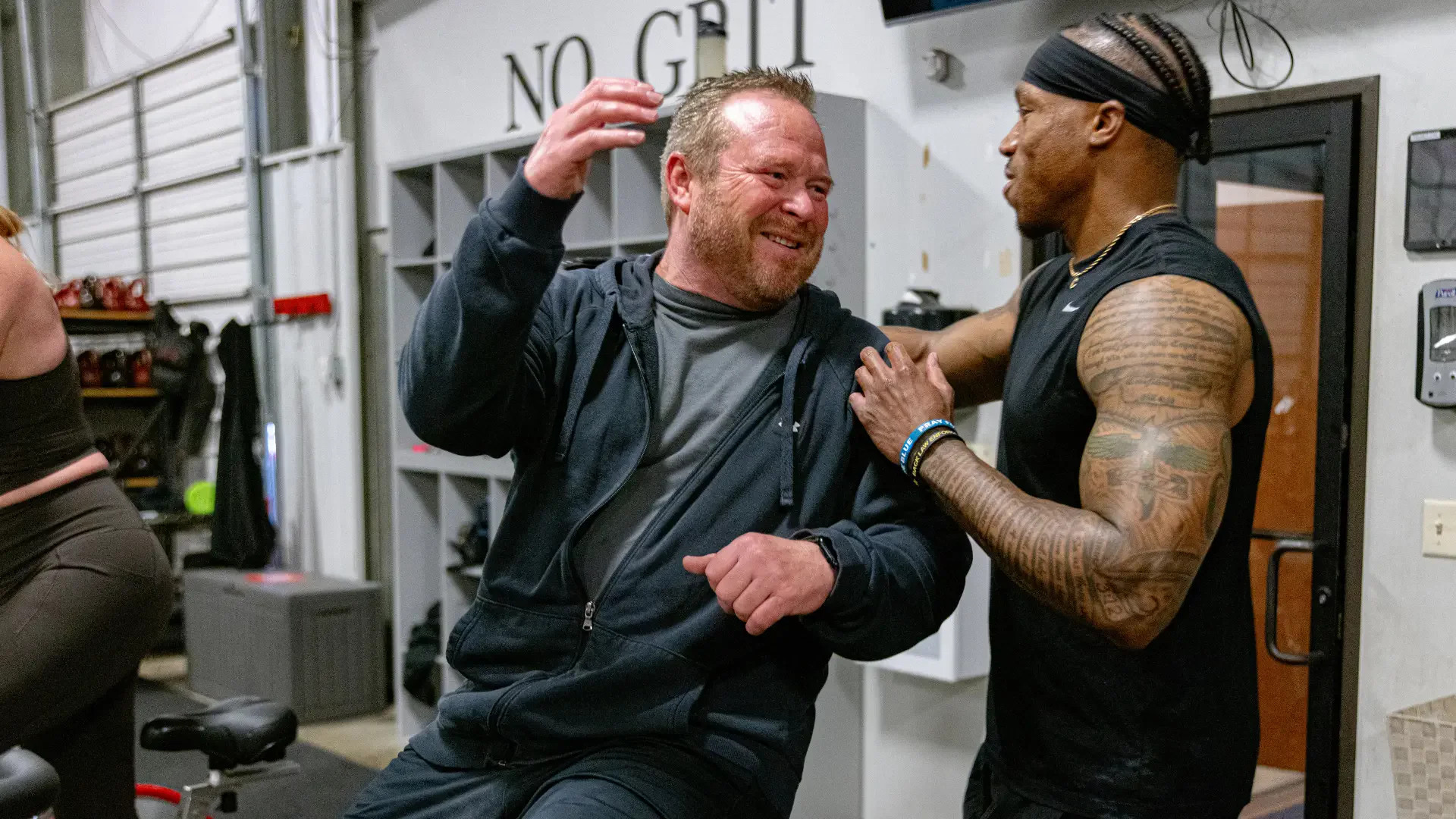 Coach correcting a member's form during a group workout at True Grit Fitness in Edmond, Oklahoma