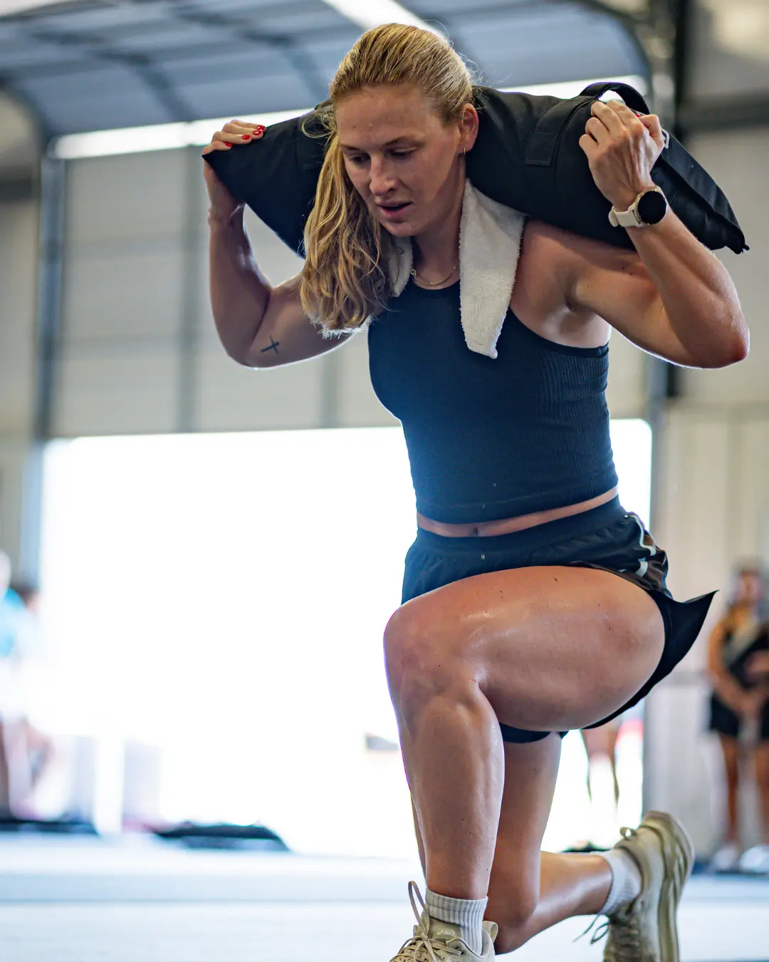 Athletes training with a sandbag during a coached weight-integrated class at True Grit Fitness in Edmond, Oklahoma