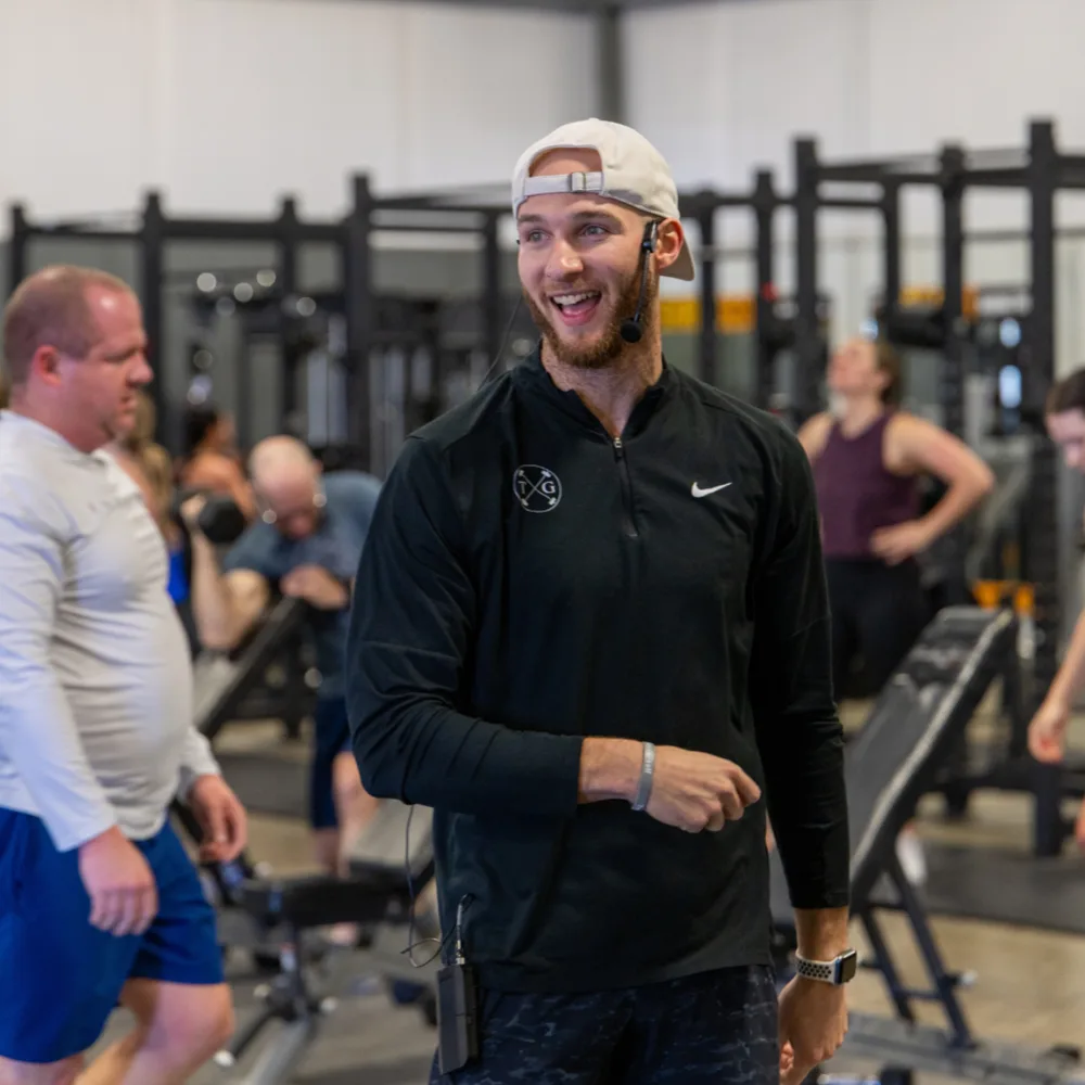 Personal trainer leading a coaching session on the gym floor at True Grit Fitness near Edmond, OK
