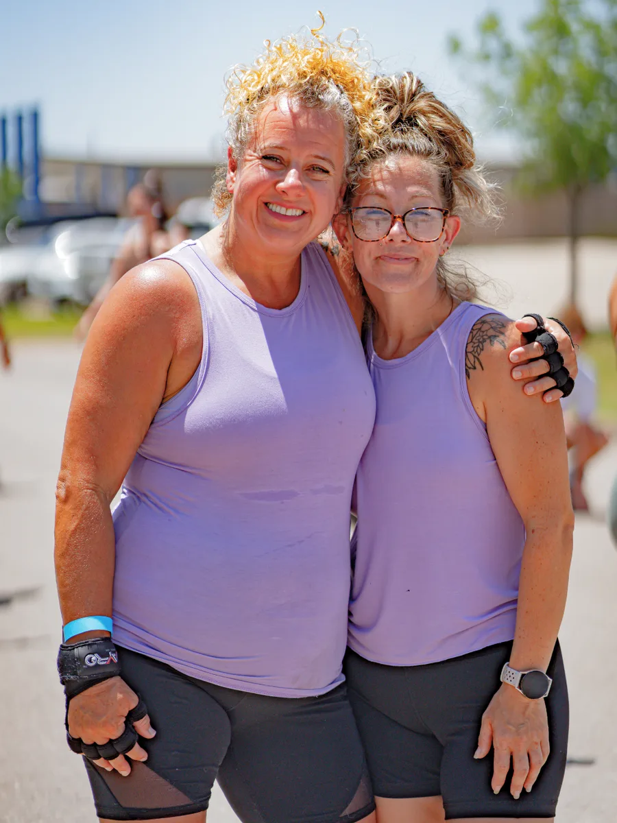Two smiling True Grit Fitness members after finishing an outdoor group workout in Edmond, Oklahoma