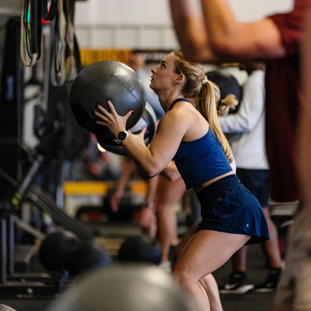Member performing wall balls during personal training conditioning work at True Grit Fitness in Oklahoma City